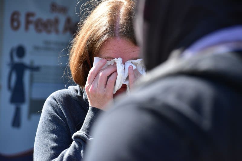 A woman reacts to pepper spray deployed by police at a Get Out The Vote march in Graham