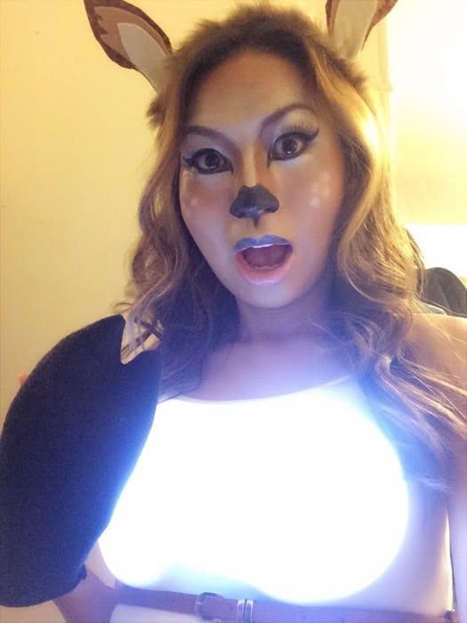 a woman dressed as a deer with headlights on her chest