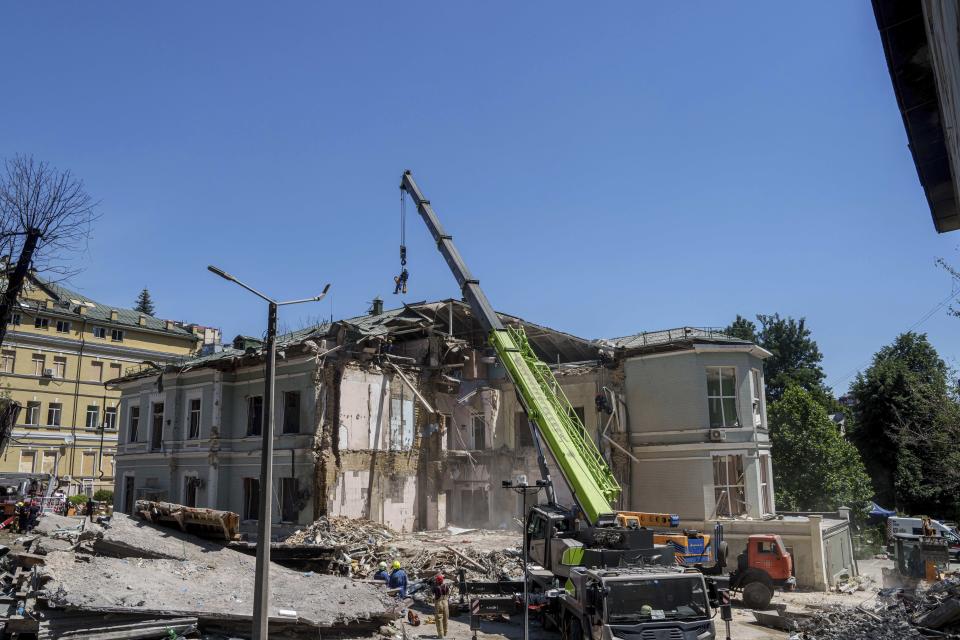 Rescue workers clear the rubble at the site of Okhmatdyt children's hospital hit by Russian missiles on Monday, in Kyiv, Ukraine, Tuesday, July 9, 2024. (AP Photo/Evgeniy Maloletka)