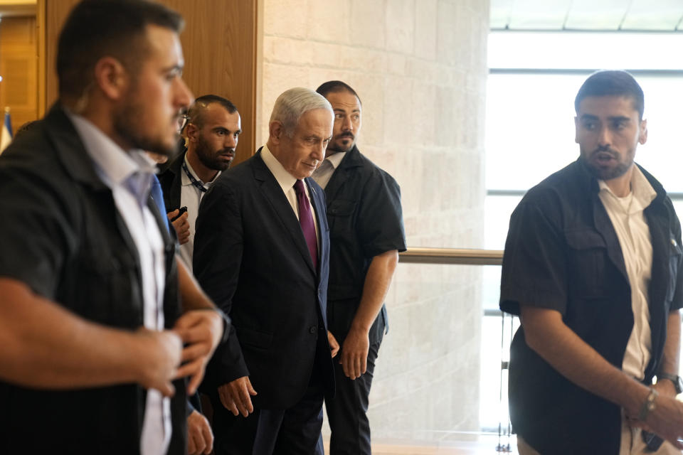 Israeli Prime Minister Benjamin Netanyahu, center, is flanked by security as he leaves a meeting with his Likud faction ahead of a vote on picking two lawmakers to serve on a judge selection panel, in the Knesset, Israel's parliament, Jerusalem, Wednesday, June 14, 2023. (AP Photo/Ohad Zwigenberg)