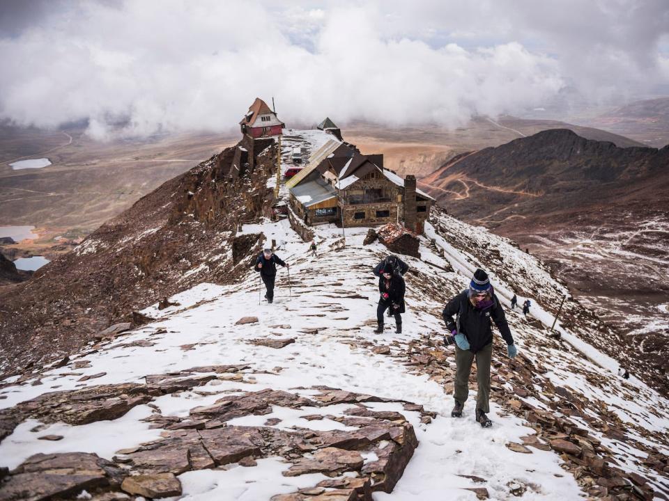 tourists climb up from the abandoned ski resort in bolivia