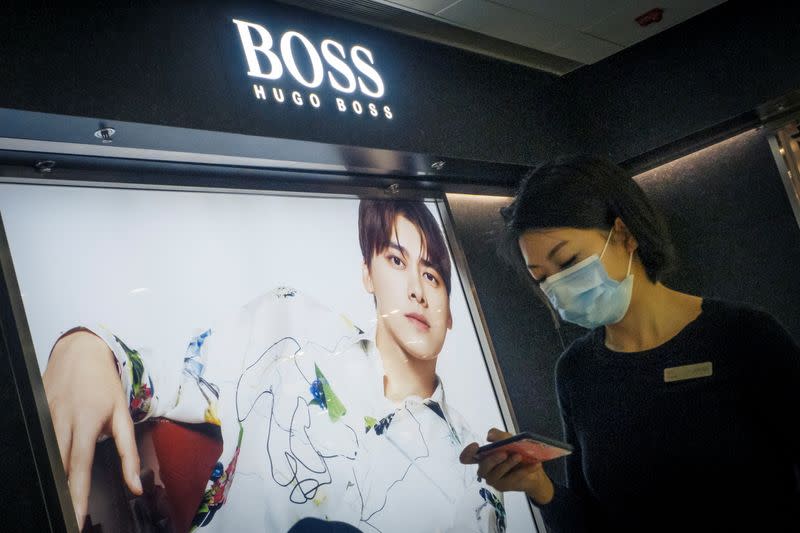 A woman walks past a store of German fashion house Hugo Boss in Beijing