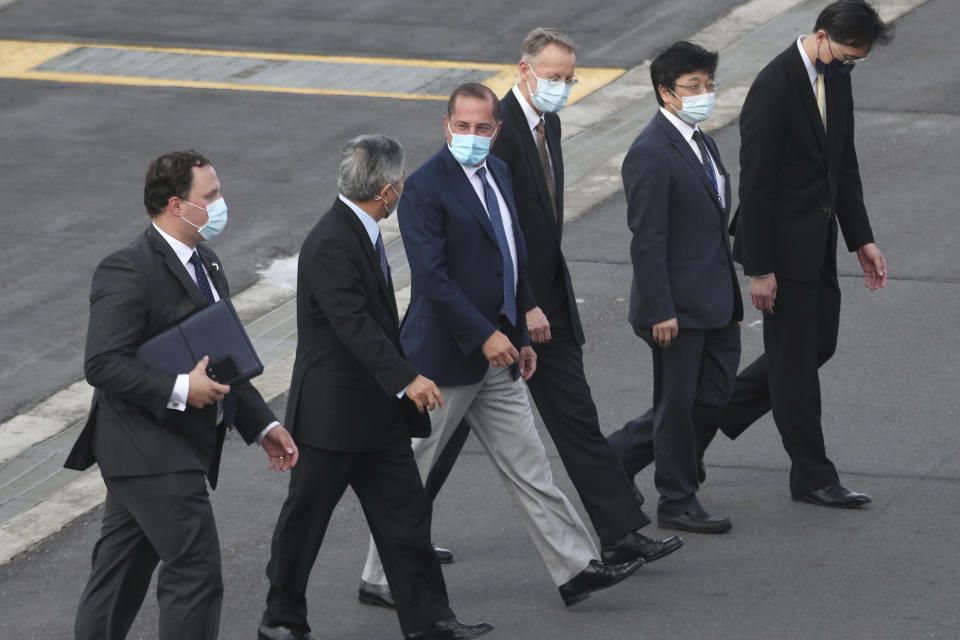 U.S. Health and Human Services Secretary Alex Azar, center, talks with Taiwanese Deputy Foreign Minister Tien Chung-kwang as he arrives at Taipei Songshan Airport in Taipei, Taiwan, Sunday, Aug. 9, 2020. Azar arrived in Taiwan on Sunday in the highest-level visit by an American Cabinet official since the break in formal diplomatic relations between Washington and Taipei in 1979. (AP Photo/Chiang Ying-ying)