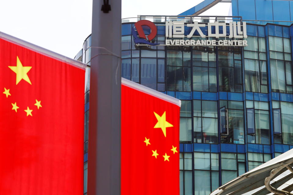 Chinese flags are seen near the logo of the China Evergrande Group on the Evergrande Center in Shanghai, China, September 24, 2021. REUTERS/Aly Song