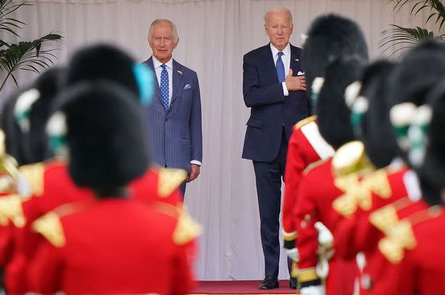 <p>JONATHAN BRADY/POOL/AFP via Getty Images</p> US President Joe Biden and Britain's King Charles III listen to the US national anthem before inspecting a guard of honour, formed by members of the Welsh Guards