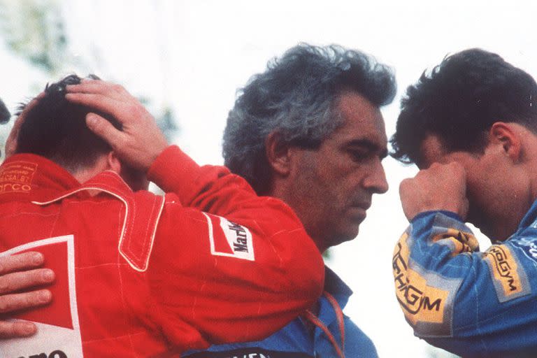 1 de mayo de 1994, el italiano Nicola Larini, con la cabeza en blanco, y el alemán Michael Schumacher, se limpia una lágrima de los ojos mientras habla con el director general de Benetton, Flavio Briatore, en el podio el accidente del Grand Prix de Fórmula Uno de San Marino en Imola, Italia