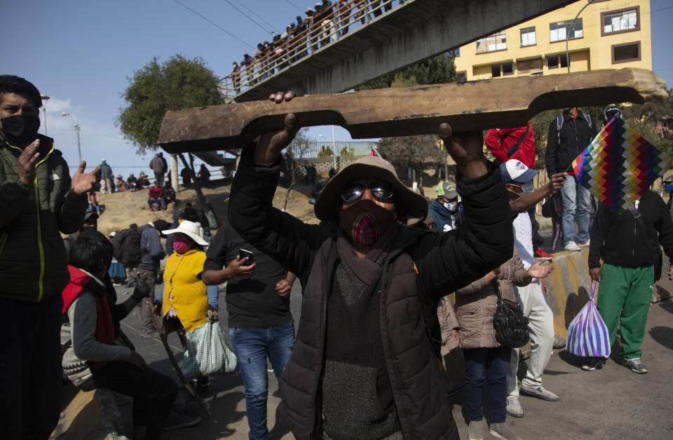 Demonstrators wearing face masks amid the COVID-19 pandemic protest the postponement of the upcoming presidential election in El Alto, Bolivia, Monday, Aug. 10, 2020. Citing the ongoing new coronavirus pandemic, the nation's highest electoral authority delayed presidential elections from Sept. 6 to Oct. 18, the third time the vote has been delayed. (AP Photo/Juan Karita)