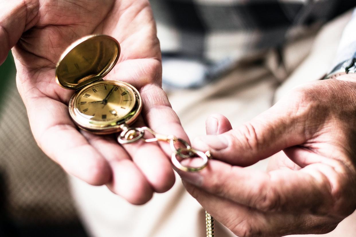 Old hands looking at a pocket watch