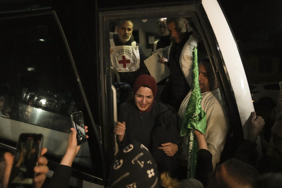 A woman smiles as she is welcomed after being released from prison by Israel, in the West Bank town of Ramallah, early Thursday, Nov. 30, 2023. International mediators on Wednesday worked to extend the truce in Gaza, encouraging Hamas militants to keep freeing hostages in exchange for the release of Palestinian prisoners and further relief from Israel's air and ground offensive. (AP Photo/Nasser Nasser)
