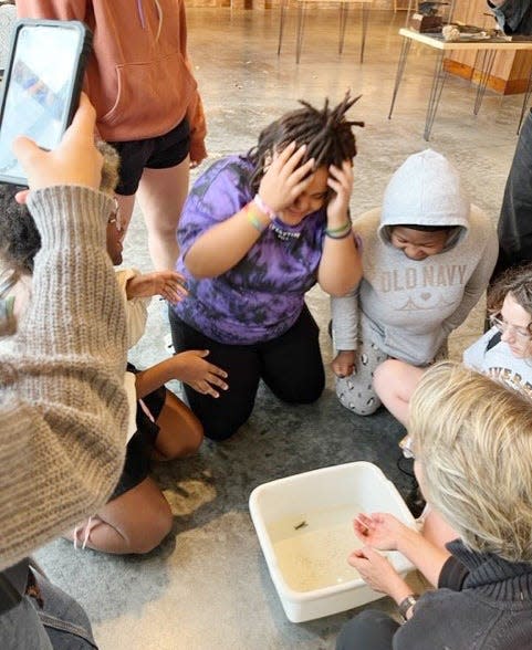 A student has a "freak out" moment while looking at crawfish during a 2022 educational youth workshop.