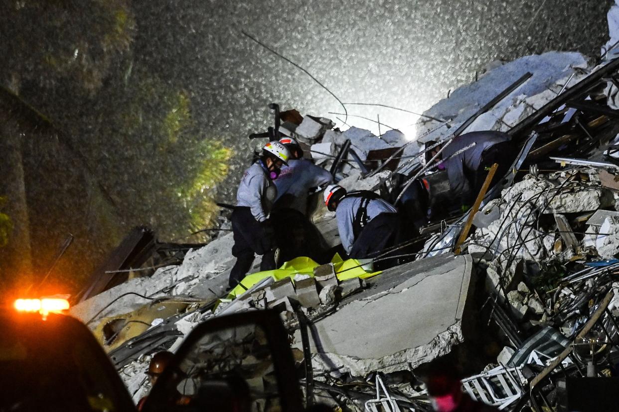 Rescue workers pull a body from the rubble of a collapsed building in Surfside, Fla., Thursday. (Photo by Chandan Khanna/AFP via Getty Images)