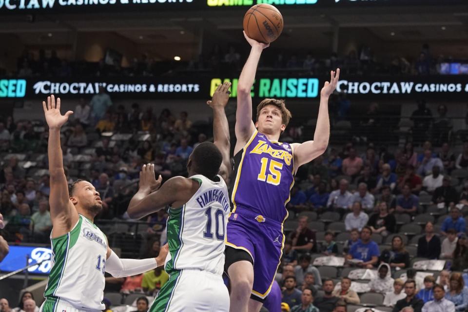 Lakers guard Austin Reaves shoots a floater over Mavericks defenders Dorian Finney-Smith (10) and Jalen Brunson (13).