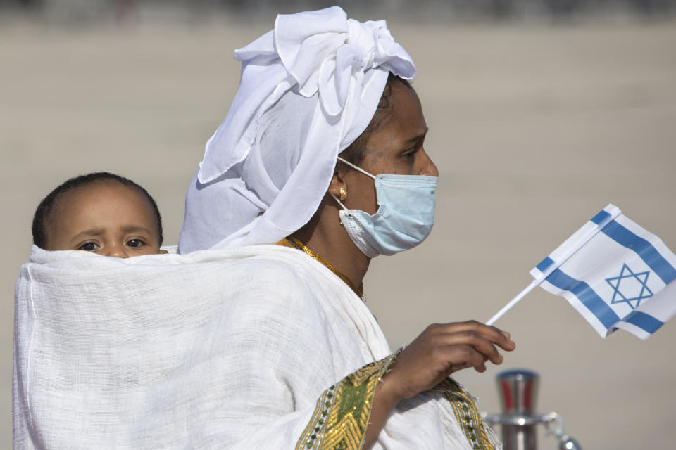 Ethiopian immigrants arrive at the Ben Gurion airport near Tel Aviv, Israel, Thursday, Dec. 3, 2020. Hundreds of Ethiopian immigrants on Thursday arrived to a festive ceremony at Israel's international airport, as the government took a step toward carrying out its pledge to reunite hundreds of families split between the two countries. (AP Photo/Sebastian Scheiner)