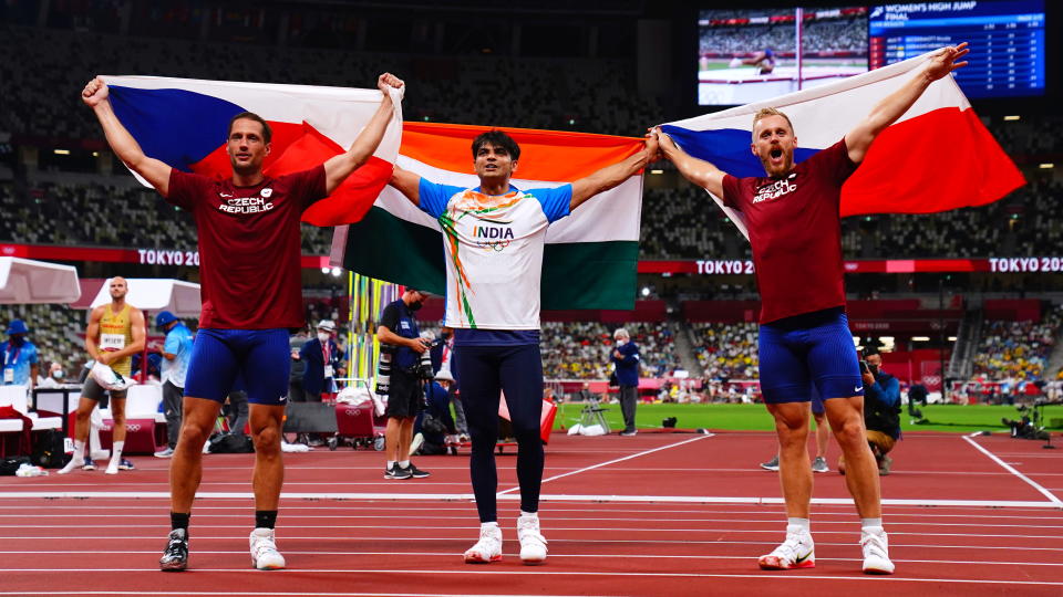 Tokyo 2020 Olympics - Athletics - Men's Javelin Throw - Final - Olympic Stadium, Tokyo, Japan - August 7, 2021. Neeraj Chopra of India, Jakub Vadlejch of Czech Republic and Vitezslav Vesely of Czech Republic celebrate with their national flags after winning gold, silver and bronze, respectively REUTERS/Aleksandra Szmigiel