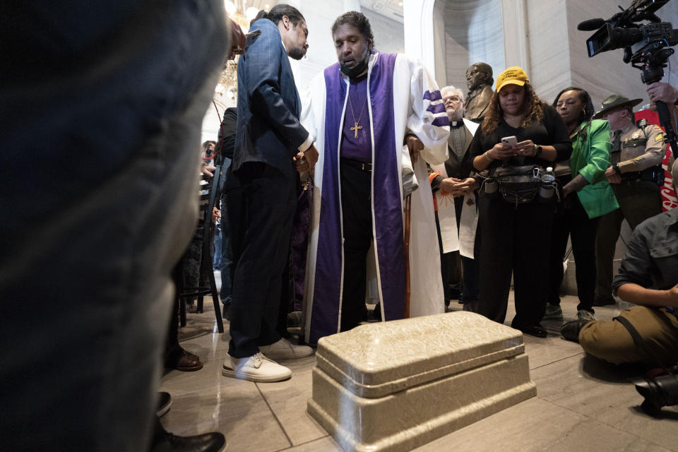 Rep. Justin Jones, D-Nashville, and Rev. William J. Barber leave a child's coffin at the door of the House chambers, Monday, April 17, 2023, in Nashville, Tenn. (AP Photo/George Walker IV)
