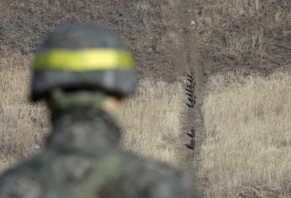 North Korean army soldiers head to inspect the dismantled South Korean guard post inside the Demilitarized Zone (DMZ) as a South Korean army soldier stands guard in the central section of the inter-Korean border in Cheorwon, Wednesday, Dec. 12, 2018. Dozens of South Korean soldiers visited former front-line North Korean guard posts on Wednesday to verify their recent removal as part of warming diplomacy by the rival Koreas while U.S.-North Korea nuclear disarmament efforts remain stalled. (AP Photo/Ahn Young-joon, Pool)