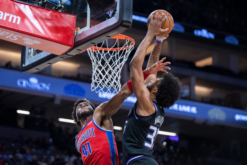 Kings forward Marvin Bagley III scores and is fouled by Pistons forward Saddiq Bey during the second half in Sacramento, Jan. 19, 2022.