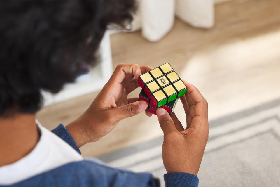 Adult tries to solved the Retro Rubik's Cube puzzle.