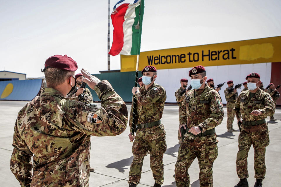 Italian Army soldiers carry the flag of the Folgore Brigade as the last Italian troops withdraw from Afghanistan, in Herat, Tuesday, June 29, 2021. The last German and Italian troops returned home from Afghanistan to low-key receptions on Tuesday and Wednesday, June 30, 2021, nearly 20 years after the first soldiers were deployed. Their withdrawal came after many other European allies pulled out their troops without much ceremony in recent days and weeks, bringing the Western mission in Afghanistan close to an end as the United States' own withdrawal looms. (Italian Defense Ministry via AP)