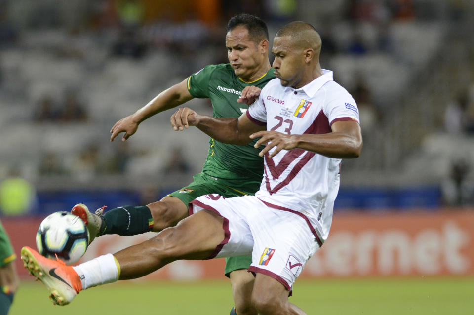 Venezuela's Salomon Rondon, front, blocks a shoot by Bolivia's Leonel Justiniano during a Copa America Group A soccer match at the Mineirao stadium in Belo Horizonte, Brazil, Saturday, June 22, 2019. (AP Photo/Eugenio Savio)