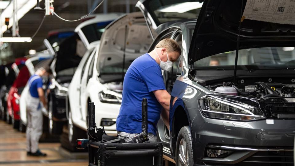 Autoproduktion mit Mund- und Nasenschutz. Die Branche fordert höhere Kaufprämien, um die eingebrochene Nachfrage anzukurbeln.