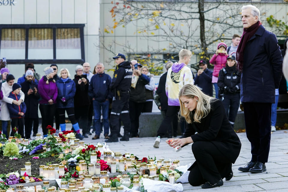 Norway's Prime Minister Jonas Gahr Stoere, right, and Minister of Justice and Emergency Management Emilie Enger Mehl lay flowers and light candles to honor the four women and a man who died in Wednesday’s bow and arrow attack in Kongsberg, Norway, Friday Oct. 15, 2021. (Terje Bendiksby/NTB via AP)