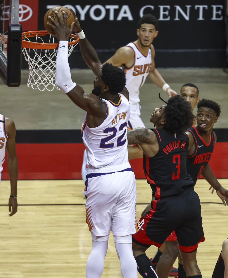 Phoenix Suns center Deandre Ayton (22) dunks against Houston Rockets guard Kevin Porter Jr. (3) during the third quarter of an NBA basketball game in Houston, Monday, April 5, 2021. (Troy Taormina/Pool Photo via AP)