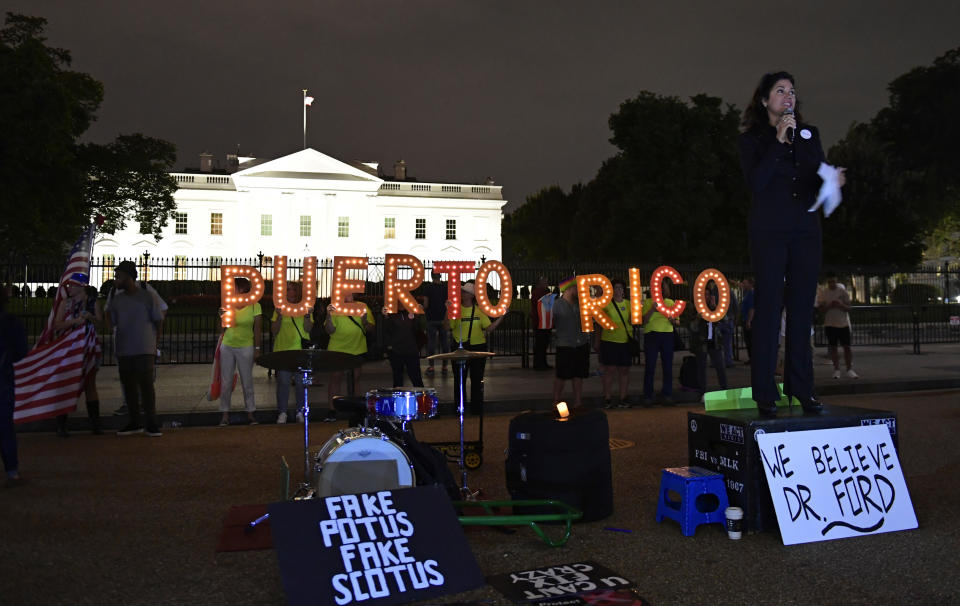 FILE - In this Sept. 20, 2018 file photo, Jennice Fuentes, right, of Power 4 Puerto Rico, speaks outside the White House in Washington, during a vigil commemorating the one-year anniversary of Hurricane Maria hitting Puerto Rico. Puerto Rico is getting much of the money it needs to rebuild its power grid three years after it was wiped out by Hurricane Maria, the island territory's governor and the White House said Friday.(AP Photo/Susan Walsh)