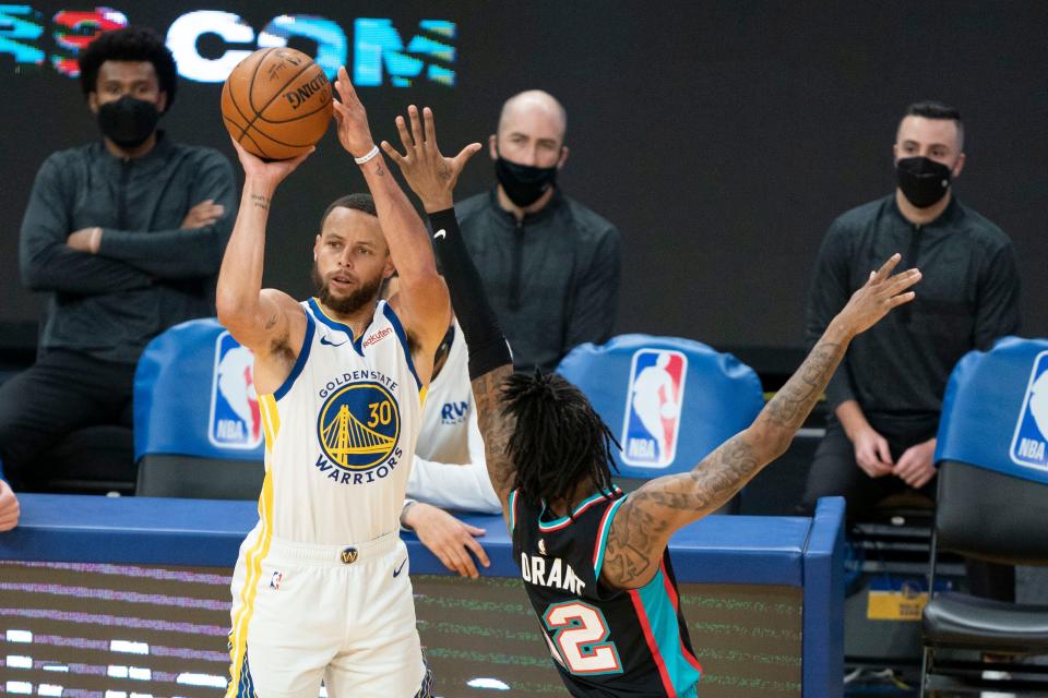 Warriors guard Stephen Curry (30) shoots over Grizzlies guard Ja Morant (12) during the third quarter on Sunday.