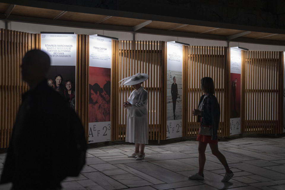 A performer stands in front of a poster during the intermission at performance of "Madame Butterfly" at the Odeon of Herodes Atticus in Athens, on Thursday, June 1, 2023. The annual arts festival in Athens and at the ancient theater of Epidaurus in southern Greece is dedicated this year to the late opera great Maria Callas who was born 100 years ago. (AP Photo/Petros Giannakouris)