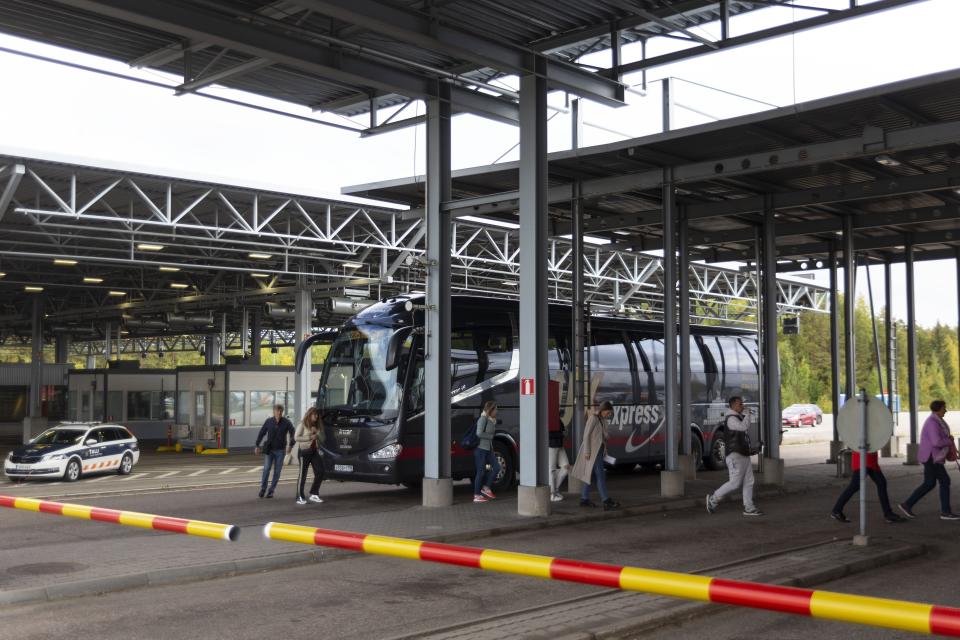 Russian passengers exit a bus to the passport control at the Vaalimaa border check point between Finland and Russia in Virolahti, Eastern Finland Wednesday, Sept. 28, 2022. The mass exodus of men — alone or with their families or friends — began Sept. 21, shortly after Putin’s address to the nation, and continued all this week. Early on, they snapped up airline tickets, which spiked in price on the few airlines still flying out of Russia. But the rest had to gas up their cars and join the long lines snaking on roads toward the borders. (Sasu M'kinen/Lehtikuva via AP)