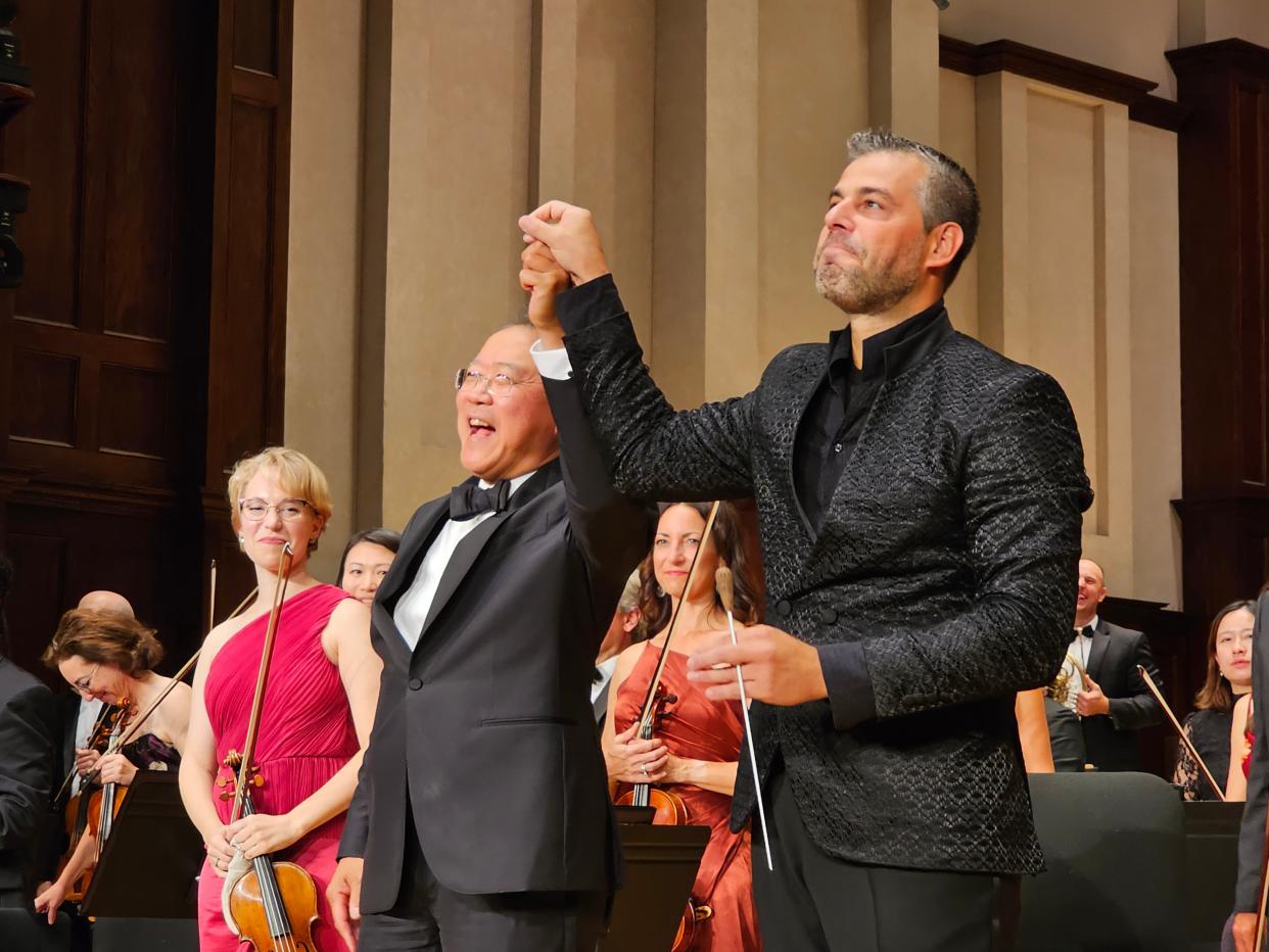 Cellist Yo-Yo Ma is joined by Detroit Symphony Orchestra music director Jader Bignamini (right) during an audience ovation at Orchestra Hall in Detroit on Saturday, Sept. 30, 2023.