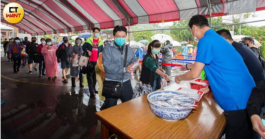 台北市松山慈惠堂連續2天免費贈送4000組快篩，民眾冒雨排隊領取。（圖／黃威彬攝）