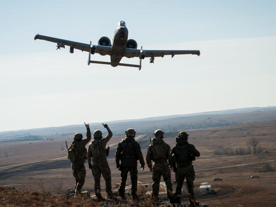 US and Estonian troops wave to a A-10 Thunderbolt II after completing close-air-support training.