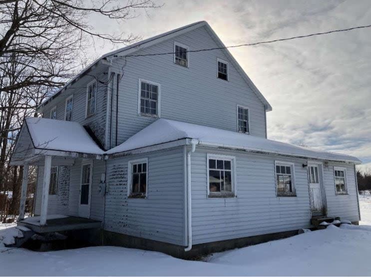 An engineer's report filed to Fredericton city council recommends demolishing a farmhouse on the Golf Club Road property. (Ace Engineering Inc./City of Fredericton - image credit)