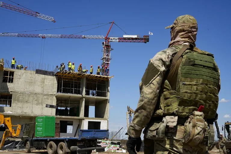 ARCHIVO - Un soldado ruso vigila el sitio de un nuevo edificio de apartamentos que está siendo construido con el apoyo del Ministerio de Defensa de Rusia, en Mariúpol, en territorio bajo el control de la República Popular de Donetsk, el miércoles 13 de julio de 2022, en el este de Ucrania. Esta fotografía fue tomada durante un recorrido organizado por el Ministerio de Defensa ruso. (AP Foto/archivo)