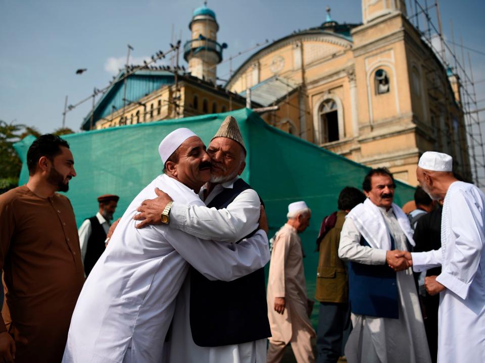 Afghan Muslims hug each other after offering Eid al-Adha prayers at Shah-e-Do Shamshira mosque in Kabul on August 11, 2019.