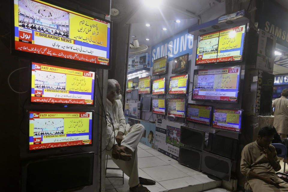 A Pakistan watches news channel flashing news regarding FATF decision, at a market in Karachi, Pakistan, Friday, June 17, 2022. An international watchdog said Friday it will keep Pakistan on a so-called "gray list" of countries that do not take full measures to combat money-laundering and terror financing but raised hopes that its removal would follow an upcoming visit to the country to determine its progress. (AP Photo/Fareed Khan)