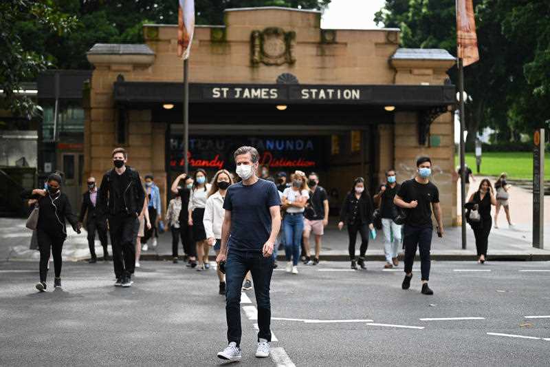 Commuters wearing face masks exit St James Station in the CBD in Sydney.