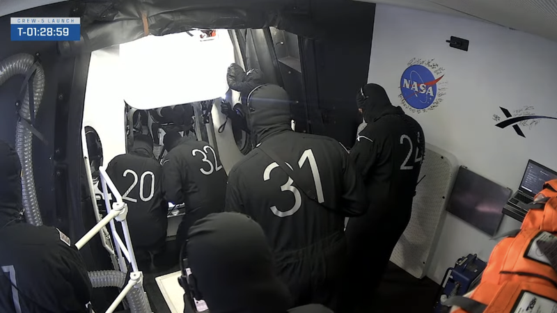 The SpaceX pad crew re-inspecting the seal shortly after having to reopen the hatch upon discovering FOD in the form of a human hair. 