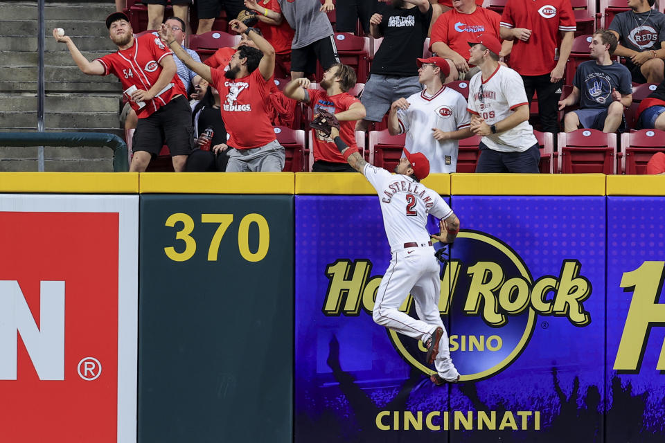 Cincinnati Reds' Nick Castellanos jumps in vain for a three-run home run by Colorado Rockies' Ryan McMahon during the sixth inning of a baseball game in Cincinnati, Friday, June 11, 2021. (AP Photo/Aaron Doster)