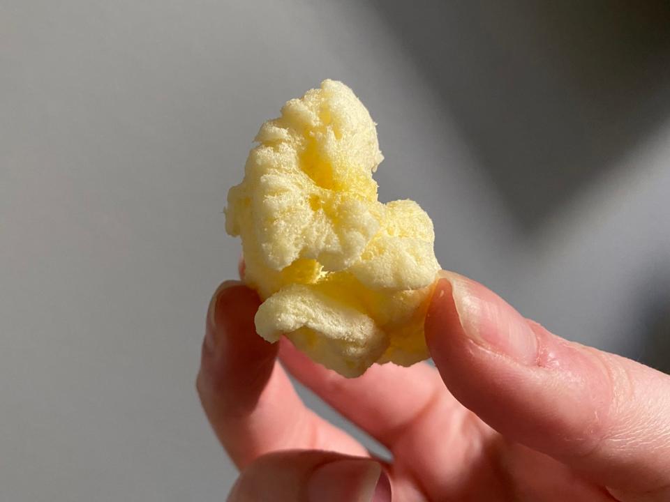 The writer holds a World's Puffiest white-cheddar corn puff