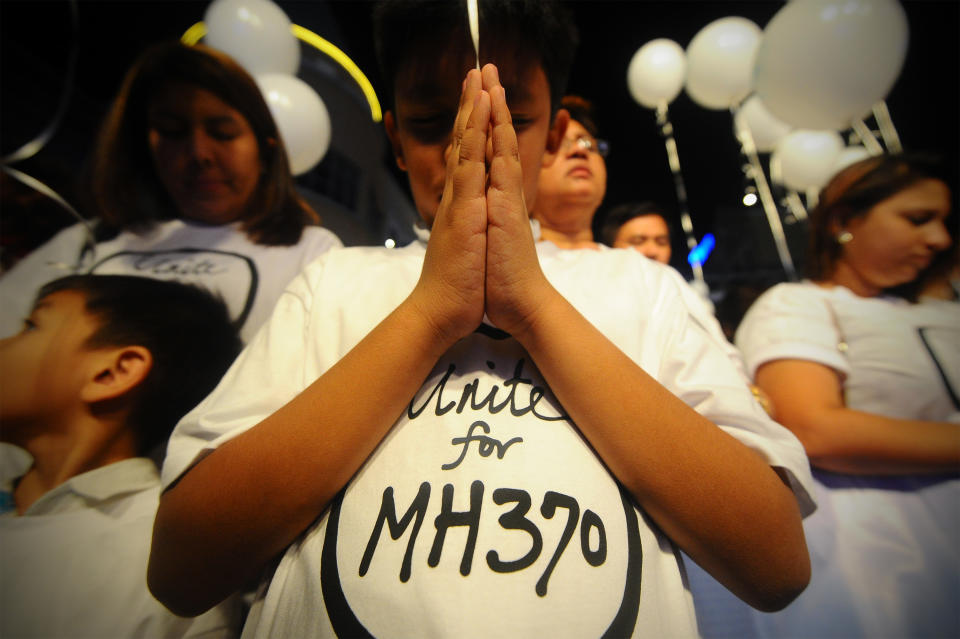 A young Malaysian boy prays, at an event for the missing Malaysia Airline, MH370, at a shopping mall, in Petaling Jaya, on the outskirts of Kuala Lumpur, Malaysia, Tuesday, March 18, 2014. A coalition of 26 countries, including Thailand, are looking for Malaysia Airlines Flight 370, which vanished March 8 with 239 people aboard on a night flight from Kuala Lumpur to Beijing. Search crews are scouring two giant arcs of territory amounting to the size of Australia — half of it in the remote seas of the southern Indian Ocean. (AP Photo/Joshua Paul)