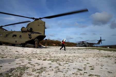 A soldier carries relief aid after Hurricane Matthew passes in Jeremie, Haiti, October 9, 2016. REUTERS/Carlos Garcia Rawlins