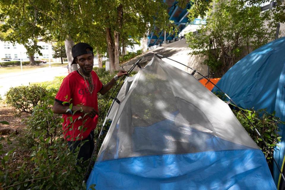 Matthew Williams puts up his tent after being forced to move from an encampment area on SW North River Drive on Thursday, Feb. 29, 2024, in Miami. Williams usually tries to pick a spot for the group to travel to together since he is more able-bodied than some of the rest.