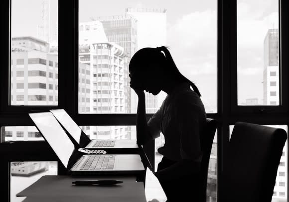 Woman at laptop looking distressed