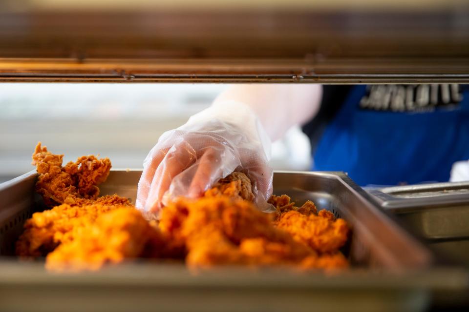 An employee builds a chicken sandwich in the the kitchen of Charlotte's Kitchen in Johnston.