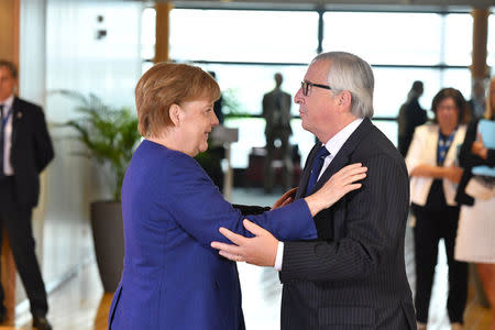 European Commission President Jean-Claude Juncker greets German Chancellor Angela Merkel during an informal EU summit on migration at EU headquarters in Brussels, June 24, 2018. Geert Vanden Wijngaert/Pool via Reuters