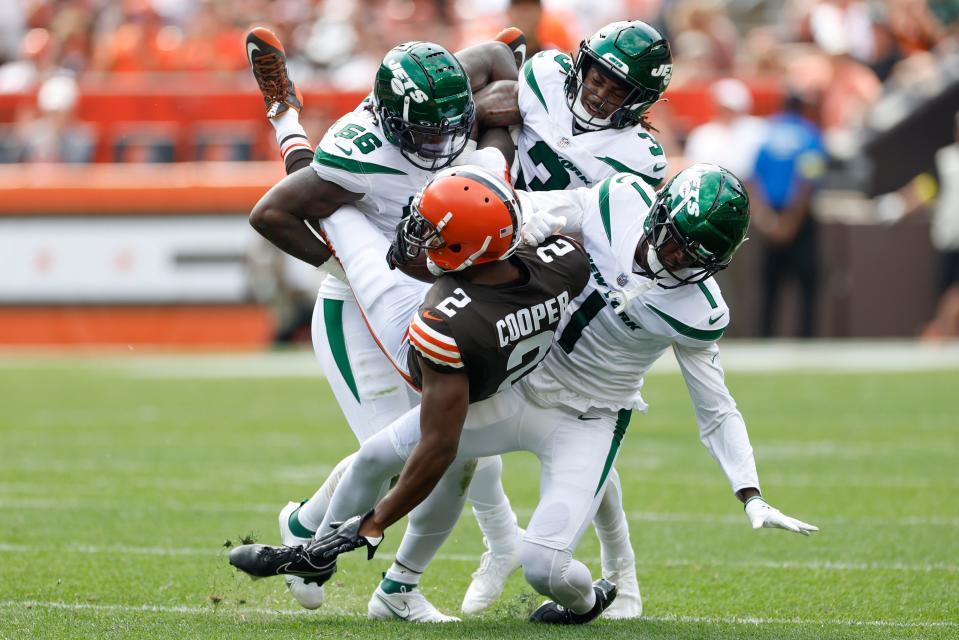 Browns wide receiver Amari Cooper is upended by New York Jets cornerback Sauce Gardner (1), linebacker Quincy Williams (56), and safety Jordan Whitehead (3) after a catch during the first half, Sunday, Sept. 18, 2022, in Cleveland.