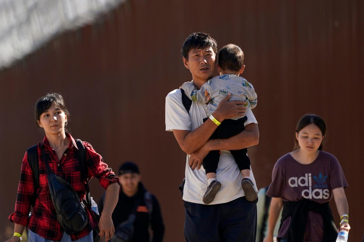 Asylum-seekers walk along the border wall near Jacumba, Calif., in October. Migrants at the southern border are increasingly from places other than Latin America, including China.
